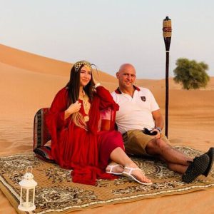 Couple sitting in desert of dubai